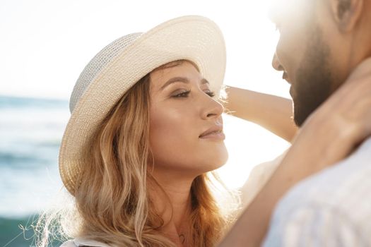 Portrait of happy young couple in love embracing each other on beach, close up