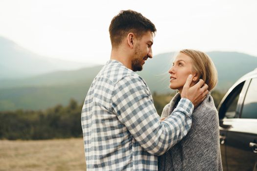 Happy loving couple hiking and hugging in mountains, close up