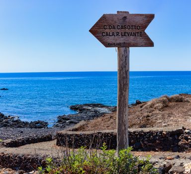 Od wooden road signs indicating the direction for the beach, Linosa