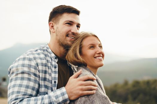 Happy loving couple hiking and hugging in mountains, close up