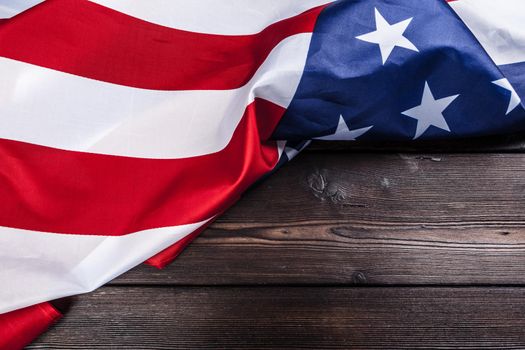 USA flag on dark wooden table background. Close up.