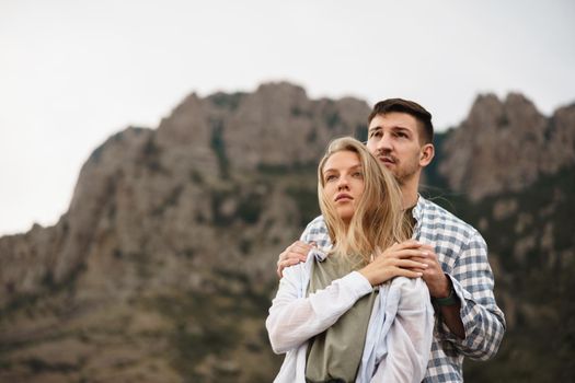 Happy loving couple hiking and hugging in mountains, close up