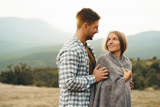 Happy loving couple hiking and hugging in mountains, close up