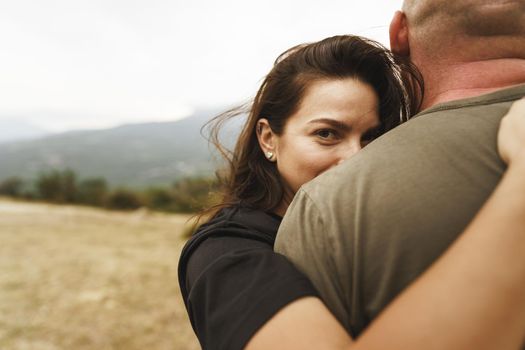 Happy couple in love hugging smiling and having fun in the mountains on foggy day