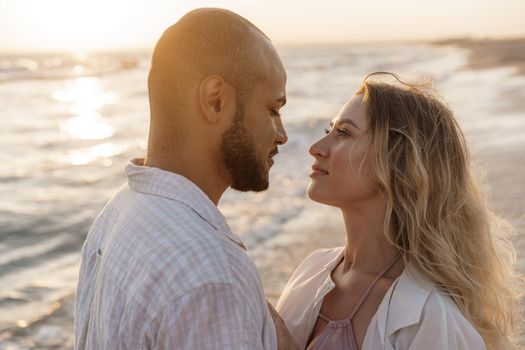 Portrait of happy young couple in love embracing each other on beach, close up