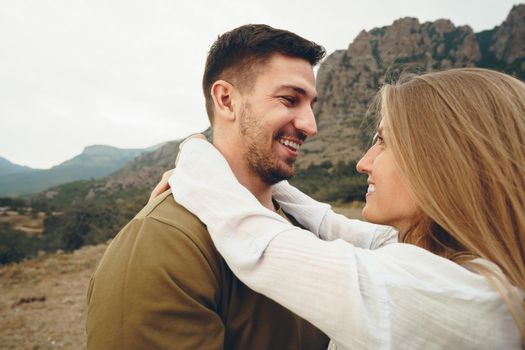 Happy loving couple hiking and hugging in mountains, close up