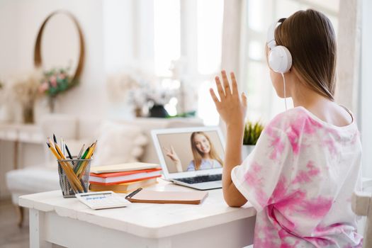 Young girl using laptop for homework at home, close up