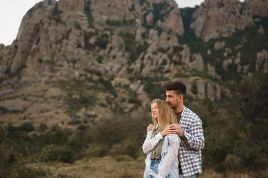 Happy loving couple hiking and hugging in mountains, close up