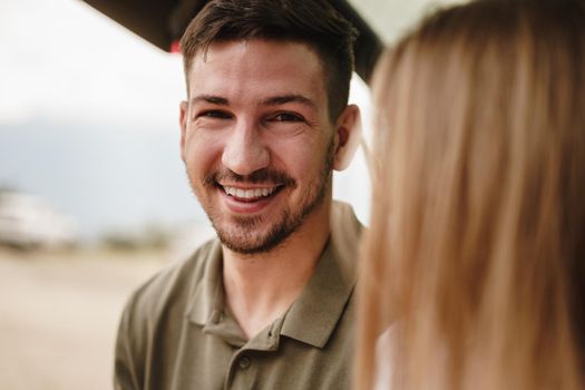 Close up photo portrait of a young man standing near car in contryside