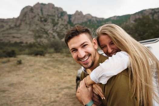 Happy loving couple hiking and hugging in mountains, close up