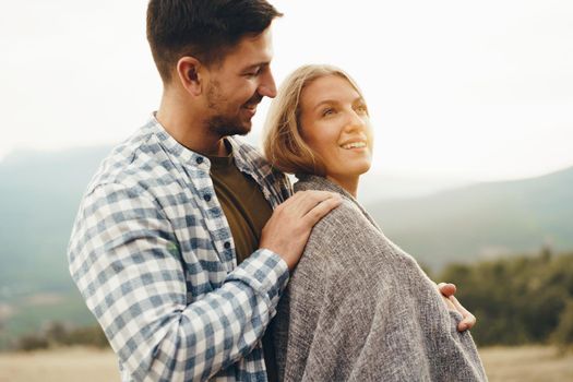 Happy loving couple hiking and hugging in mountains, close up