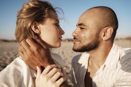 Portrait of happy young couple in love embracing each other on beach, close up