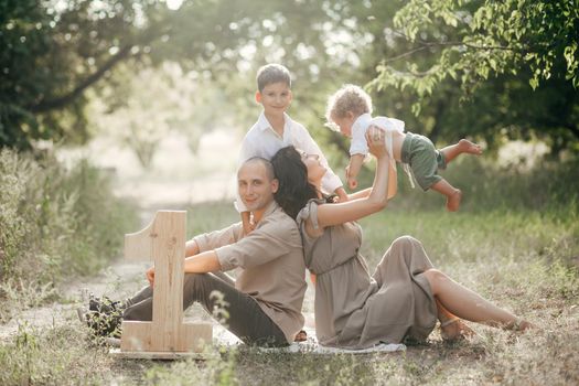 Happy young family with two children on wheat summer field. Adventure, travel, tourism, hike and people concept - happy family walking