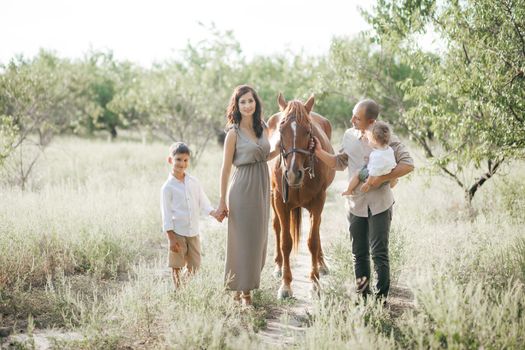 Happy young family with two children on wheat summer field. Adventure, travel, tourism, hike and people concept - happy family walking