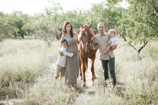 Happy young family with two children on wheat summer field. Adventure, travel, tourism, hike and people concept - happy family walking