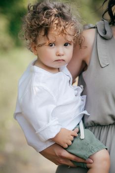 Closeup portrait of a little baby boy on wheat summer field. Parenthood concept. Adventure, travel, tourism, hike and people concept - happy family walking