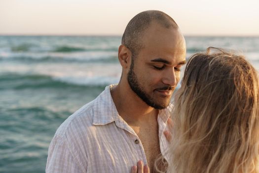 Portrait of happy young couple in love embracing each other on beach, close up