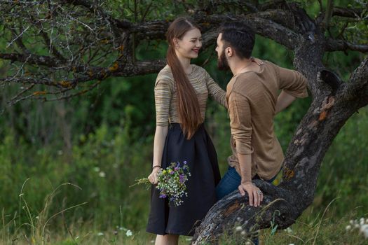 young couple hugging near a tree