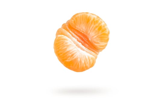 A piece of mandarin isolated on a white background, falling casting a shadow. Individual segments of tangerine slices, for inserting into a project or design