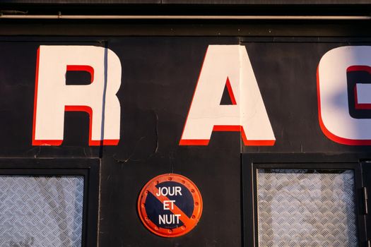 Sign prohibiting parking day and night on the wall of a Parisian establishment