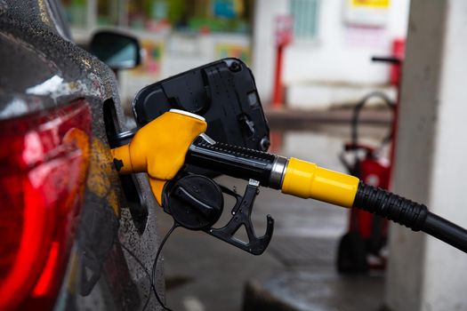 Pumping gasoline fuel in car at gas station. Refueling automobile with gasoline or diesel with a fuel dispenser. Fuel business