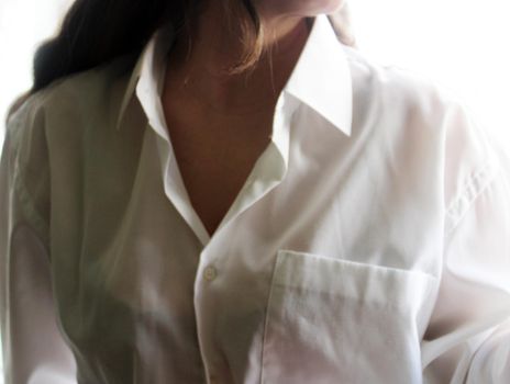 Beautiful girl with dark long hair in a white shirt..