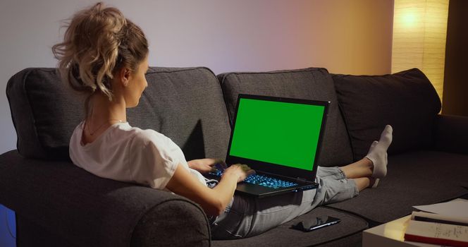 Chroma Key Green Screen Laptop Computer. Woman working typing home evening late. Remote work. Technology concept.