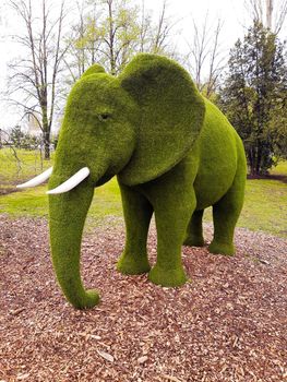 Decorative sculpture of an elephant in a city park close-up.