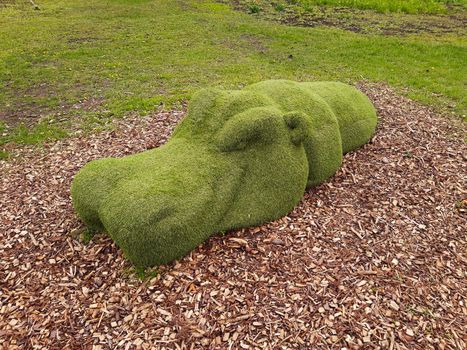 Decorative sculpture of a hippopotamus in a city park close-up.