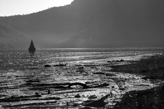 Black and white landscape showing some dirt and a flooded church in Sau swamp in Catalonia