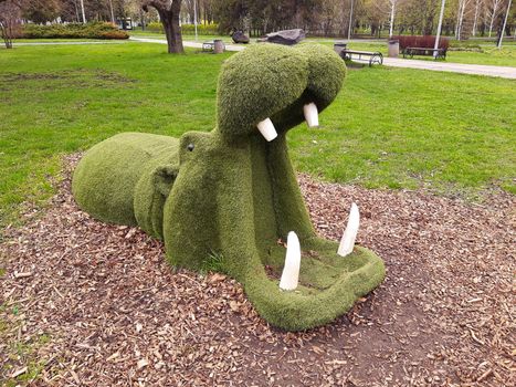 Decorative sculpture of a hippopotamus in a city park close-up.