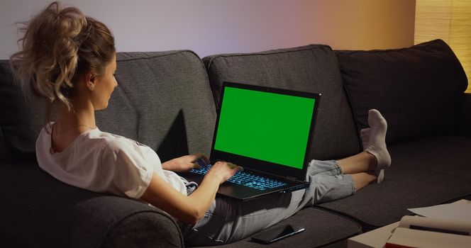 Chroma Key Green Screen Laptop Computer. Woman working typing home evening late. Remote work. Technology concept.