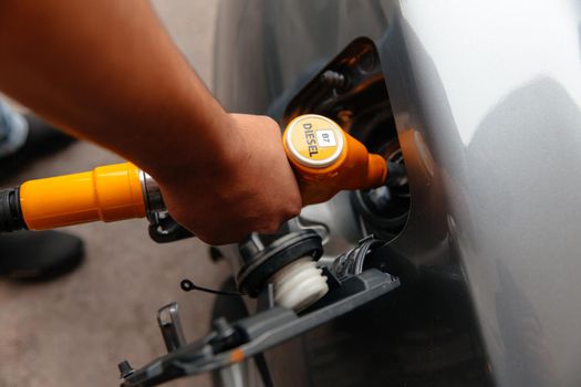 Hand Man Refill and filling Oil Gas Fuel at station. Pumping gasoline fuel in car at gas station. Refueling automobile with gasoline or diesel with a fuel dispenser. Fuel business