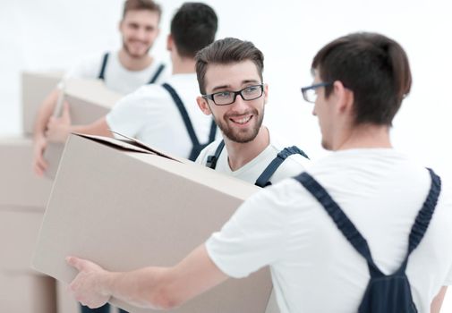 Young movers holding boxes standing in a row, isolated on white background.