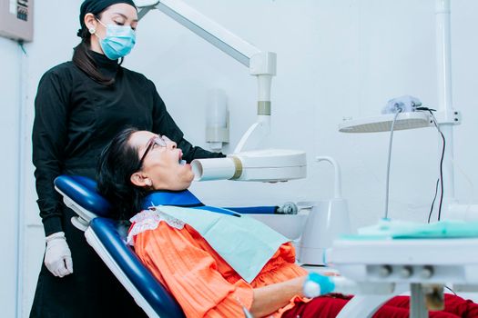 A female dentist performing dental x-rays, Female dentist performing x-rays on a patient, Female dentist performing dental x-rays