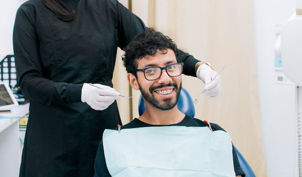 Dentist examining mouth to smiling patient, Female dentist doing root canal to female patient, Female dentist with lying patient, Dentist performing stomatology
