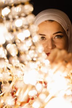 Fashion muslim model near big expensive chandelier. Islamic religion