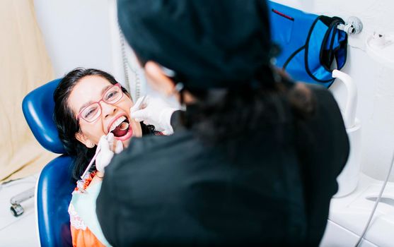 Top view of dentist doing dental checkup, patient checked by dentist, close up of dentist with patient, dentist doing root canal treatment on patient