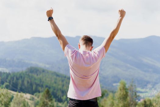 Tourism travelling in Ukraine. Man girl raised her hands up and enjoys the mountain hills view. Feeling freedom in Karpathian mountains.