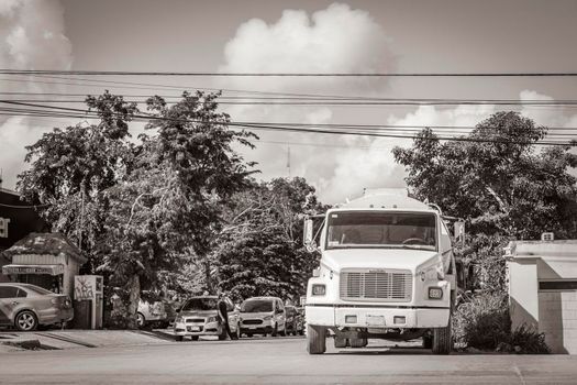 Tulum Mexico 02. February 2022 Old black and white picture of trucks dump truck and other industrial vehicles on typical street road and cityscape in Tulum in Mexico.