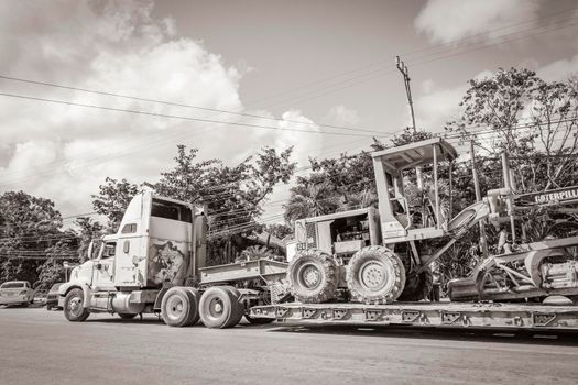 Tulum Mexico 02. February 2022 Old black and white picture of trucks dump truck excavator and other industrial vehicles on typical street road and cityscape in Tulum in Mexico.