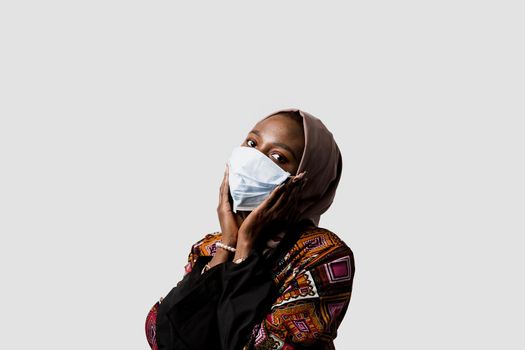 Black muslim business woman in medical mask weared in hijab on white backgroud. Cryptocurrency investments in bitcoin. Successful black girl.