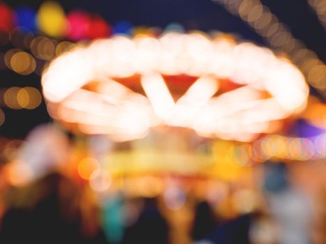 Red Square decorated for New Year and Christmas fair. Blurred background with colorful carousel decorated with light bulbs. Moscow, Russia.