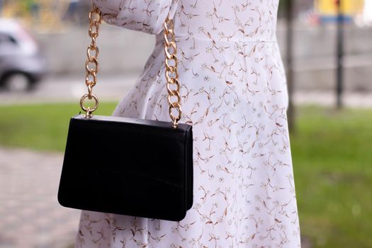 close up of womans hand holding fashionable little black bag. Product photography. stylish handbag and purse for women.