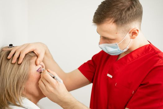 Blepharoplasty markup close-up on the face before the plastic surgery operation for modifying the eye region of the face in medical clinic. Doctor doing plastic cosmetic operation