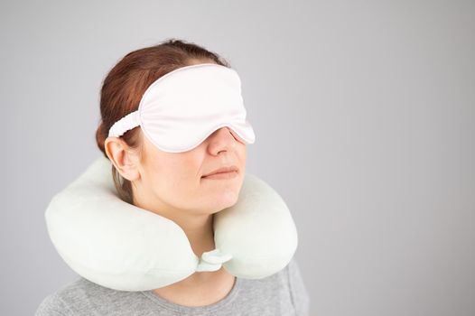 Caucasian woman with travel pillow and sleeping mask isolated on white background