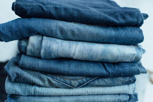 Stack of a stack of old jeans various shades of blue jeans. Denim jeans texture. Denim background texture for design. Canvas denim texture. Blue denim background.