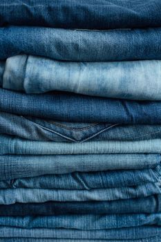 Stack of a stack of old jeans various shades of blue jeans. Denim jeans texture. Denim background texture for design. Canvas denim texture. Blue denim background.