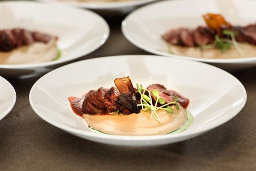 veal tenderloin with fried mashed potatoes and micro green.