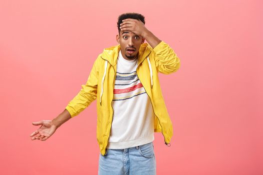 Dude where is my car. Portrait of shocked frustrated and confused handsome stylish young african american male student in yellow evening jacket holding hand on forehead shrugging being clueless. Emotions concept